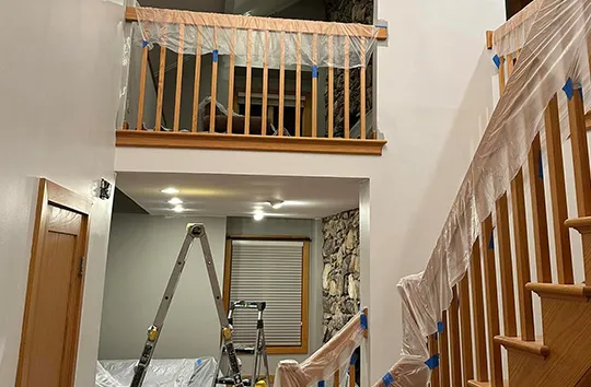 Staircase and tools in a home remodeling project, plastic covered.