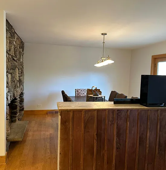 Cozy dining area with stone wall and wooden accents.