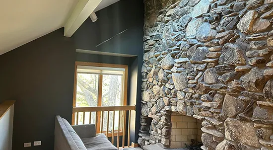 A renovated room featuring a stone fireplace.